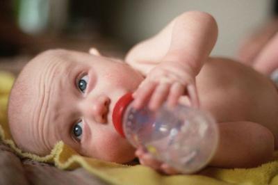 Малыш пьет воду с бутылочки Малыш пьет воду с бутылочки