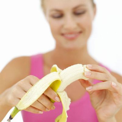Женщина чистит банан