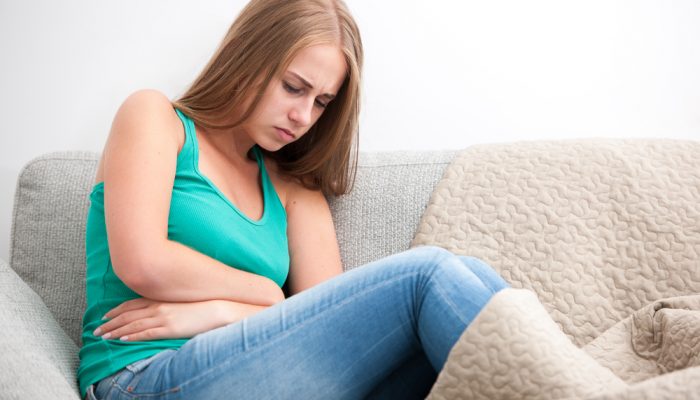 Woman having abdominal pain, upset stomach or menstrual cramps