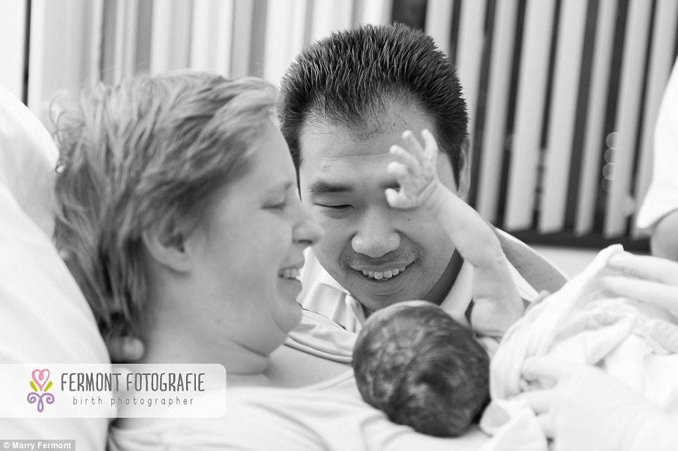 Welcome to the world: As new parents gaze adoringly at their newborn they appear to get a cheerful wave